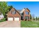 Two-story brick home boasts a well-maintained lawn, attached garage, and classic architectural details at 1050 Merrywood Dr, Newton, NC 28658