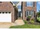 Close-up of a two-story home's front entrance, showing brick, siding, and landscaped walkway at 1050 Merrywood Dr, Newton, NC 28658