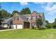 Charming two-story brick home featuring an attached two-car garage and a lush green lawn at 1050 Merrywood Dr, Newton, NC 28658