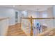 Upstairs hallway featuring wood flooring, white banisters, and a view of the staircase at 1050 Merrywood Dr, Newton, NC 28658
