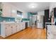 White cabinets, stainless steel appliances, wood floors and colorful walls make a bright kitchen at 1050 Merrywood Dr, Newton, NC 28658