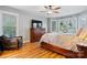 Comfortable main bedroom featuring hardwood floors, a ceiling fan, and natural light from three windows at 1050 Merrywood Dr, Newton, NC 28658
