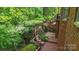 Multi-level wooden deck overlooking lush, mature landscaping makes this backyard an oasis at 11424 Stonebriar Dr, Charlotte, NC 28277