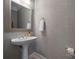Powder room with neutral wallpaper, pedestal sink, modern fixtures, and a framed mirror at 11424 Stonebriar Dr, Charlotte, NC 28277