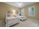 Bright bedroom with neutral walls, carpet flooring, ceiling fan and two twin beds each with a nightstand at 11424 Stonebriar Dr, Charlotte, NC 28277