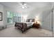 This bright bedroom features a ceiling fan and a large window with plantation shutters at 11424 Stonebriar Dr, Charlotte, NC 28277
