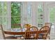 Sunny breakfast nook with an oval table set, large window with shutters, and lush view at 11424 Stonebriar Dr, Charlotte, NC 28277