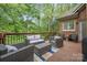 Outdoor living space with modern furniture and a view of wooded backyard at 11424 Stonebriar Dr, Charlotte, NC 28277
