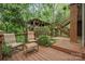 Back deck with outdoor seating, stairs, and a pergola surrounded by lush greenery at 11424 Stonebriar Dr, Charlotte, NC 28277