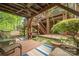 Under-deck patio with seating, rugs, and a view of the lush landscaped backyard at 11424 Stonebriar Dr, Charlotte, NC 28277