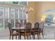 Bright dining room with large window, shutters, chandelier, and classic wood table set at 11424 Stonebriar Dr, Charlotte, NC 28277