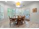 Bright dining room featuring tile floors, shutters on the many windows, and a wooden dining table set for six at 11424 Stonebriar Dr, Charlotte, NC 28277