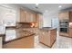 Open-concept kitchen featuring light wood cabinets, granite countertops, stainless appliances, and a tile backsplash at 11424 Stonebriar Dr, Charlotte, NC 28277