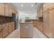 Spacious kitchen features an island cooktop, stainless appliances, light wood cabinets, and granite countertops at 11424 Stonebriar Dr, Charlotte, NC 28277