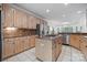 Large open kitchen features an island cooktop, stainless appliances, light wood cabinets, and granite countertops at 11424 Stonebriar Dr, Charlotte, NC 28277