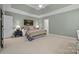 This main bedroom features a ceiling fan, carpet, and a door to the ensuite bathroom at 11424 Stonebriar Dr, Charlotte, NC 28277