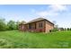 Brick home back exterior featuring a covered porch, large yard and manicured lawn at 121 Capstone Ct, Statesville, NC 28625