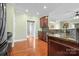 Open kitchen with cherry cabinets, granite countertops, stainless appliances, and wood floors at 121 Capstone Ct, Statesville, NC 28625