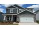 Charming two-story home features a stone facade, carriage garage door, and stylish gray shingle siding at 1216 Morehead Dr, Salisbury, NC 28144