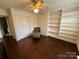 Bedroom with hardwood floors features built-in shelving, a ceiling fan, and a closet at 1300 Queens Rd # 210, Charlotte, NC 28207