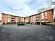 Brick apartment building with parking and balconies on a sunny day at 1300 Queens Rd # 210, Charlotte, NC 28207