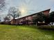 Exterior view of a condominium building with green lawn and trees at 1300 Queens Rd # 210, Charlotte, NC 28207