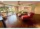 Inviting living room featuring dark hardwood floors, balcony access, an open kitchen view, and modern decor at 1300 Queens Rd # 210, Charlotte, NC 28207
