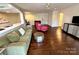 Open living room with dark hardwood floors, leading to a kitchen, and tastefully decorated with contemporary furniture at 1300 Queens Rd # 210, Charlotte, NC 28207