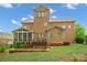 Backyard featuring a brick home, deck, screened porch, stone patio, manicured lawn and landscaping at 13044 Fen Ct, Huntersville, NC 28078