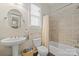 Well-lit bathroom featuring a pedestal sink, tiled shower, and a large window, blending functionality with natural light at 13044 Fen Ct, Huntersville, NC 28078