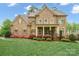 Brick two-story home with manicured lawn and colorful flowering shrubs accenting the facade at 13044 Fen Ct, Huntersville, NC 28078