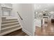 Hallway entrance with staircase and sightlines into the kitchen and living room, providing an inviting transition at 13044 Fen Ct, Huntersville, NC 28078