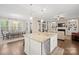 Open-concept kitchen featuring granite countertops, stainless steel appliances, and a center island overlooking the living area at 13044 Fen Ct, Huntersville, NC 28078