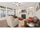 Cozy living room with a fireplace, built-in shelves, ceiling fan, and large windows at 13044 Fen Ct, Huntersville, NC 28078