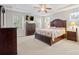 This bright main bedroom features a ceiling fan, large windows, and a floral patterned comforter at 13044 Fen Ct, Huntersville, NC 28078