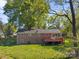 Back exterior of a brick home with a wooden deck, and a large grassy yard at 1337 Eastside Ave, Albemarle, NC 28001