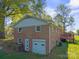 Back exterior view of the brick home featuring a garage and an attached wooden deck at 1337 Eastside Ave, Albemarle, NC 28001