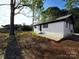 Rear view of white brick home with black roof, featuring clean lines and modern appeal at 1407 Clarksville Campground Rd, Monroe, NC 28112