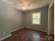 Bedroom features wood-look flooring, a ceiling fan, and natural light at 1407 Clarksville Campground Rd, Monroe, NC 28112