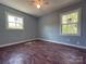 Bedroom featuring hardwood floors, blue walls, and two bright windows at 1407 Clarksville Campground Rd, Monroe, NC 28112