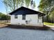 Side view of white brick home with black roof, featuring clean lines and modern appeal at 1407 Clarksville Campground Rd, Monroe, NC 28112