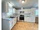 Bright kitchen features white cabinets, stainless steel appliances, and hardwood flooring at 1407 Clarksville Campground Rd, Monroe, NC 28112