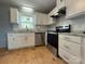 Bright kitchen features white cabinets, stainless steel appliances, and hardwood flooring at 1407 Clarksville Campground Rd, Monroe, NC 28112