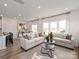 Bright living room with modern furniture, neutral color palette, wood floors, and large windows showcasing the backyard view at 143 Shepherds Landing Dr, Mooresville, NC 28115