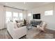 Cozy living room with a comfortable sofa, a modern entertainment center, and natural light from the large windows at 143 Shepherds Landing Dr, Mooresville, NC 28115