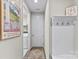 Hallway leading to laundry room, featuring coat hooks and a Pinehurst golf poster at 15710 Oleander Dr, Charlotte, NC 28278