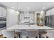 Stylish kitchen features white cabinets, stainless steel appliances, a large island with seating, and modern lighting at 15710 Oleander Dr, Charlotte, NC 28278