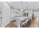 Modern kitchen with white cabinets, stainless appliances, an island with bar stools, and sleek pendant lighting at 15710 Oleander Dr, Charlotte, NC 28278