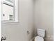 Simple powder room with toilet and window at 15710 Oleander Dr, Charlotte, NC 28278