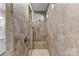Walk-in shower featuring stylish neutral tilework, a built-in bench, and a shower head at 15710 Oleander Dr, Charlotte, NC 28278